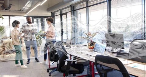 Collaborating Diverse Team Sharing Tablet and Papers in Bright Open-Plan Office Workspace