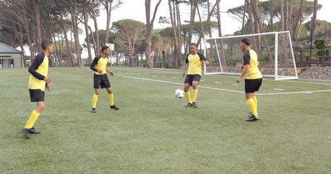 Soccer Players Practicing Passing Drills on Field in Uniforms