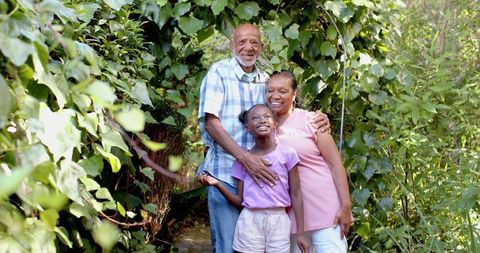 Happy Family Enjoying Time Outdoors in Lush Greenery