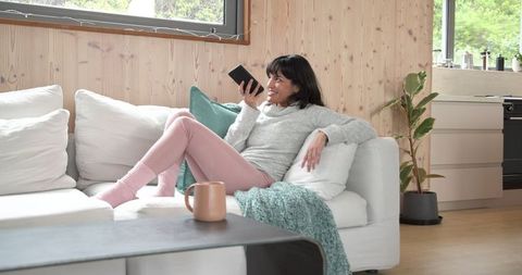 Relaxed woman enjoying conversation in cozy living room