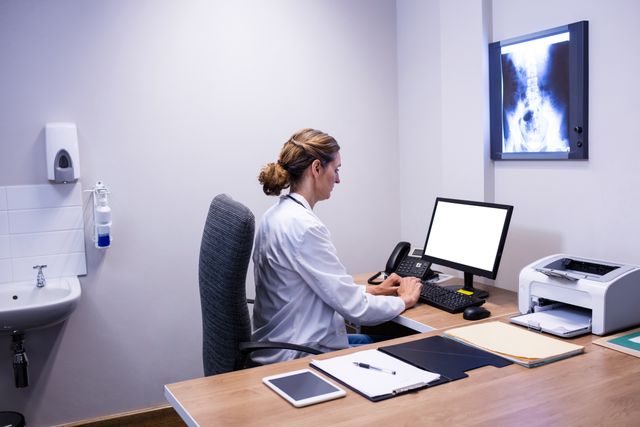 Attentive doctor working on computer in clinic at hospital