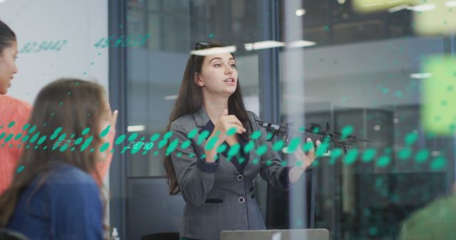 Female business leader presenting data to a team in a modern office. Suitable for concepts related to business leadership, data analysis, teamwork, corporate meetings, professional environments, and technological advancements in business.