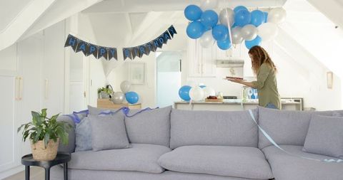 Woman arranging birthday cupcakes in decorated living room