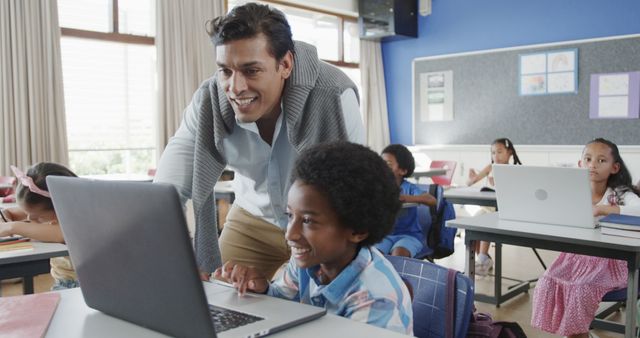 Smiling Teacher Assisting Student with Laptop in Classroom - Download Free Stock Images Pikwizard.com