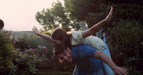 Joyful Couple Enjoying Piggyback Ride in Lush Garden - Download Free Stock Images Pikwizard.com