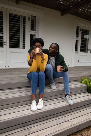 Couple Relaxing with Hot Drinks on Rustic Porch