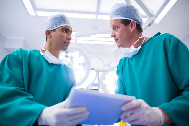 Surgeons using digital tablet in operation theater of hospital