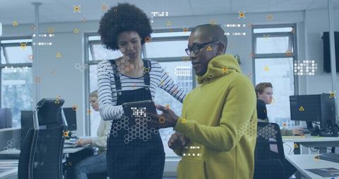 Colleagues Collaborating on Tablet in Modern Tech Office