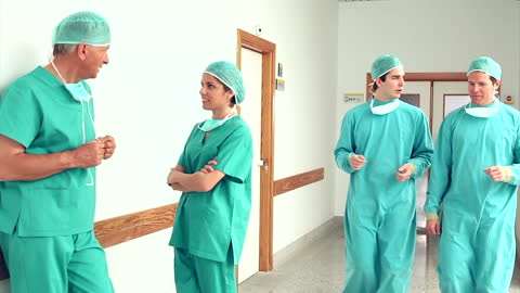 Team of Surgeons Talking in Hospital Corridor