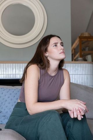 Thoughtful Young Woman Sitting in Contemporary Living Room Interiors