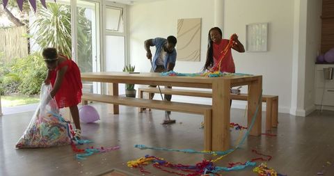 Family collaborating to clean up after home party