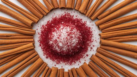 Cinnamon Stick Ring Surrounding Red and White Sugar Crystals for Holiday Baking Flatlay