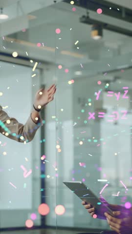 Presenter gesturing at glass equations with peer tapping tablet for futuristic tech collaboration