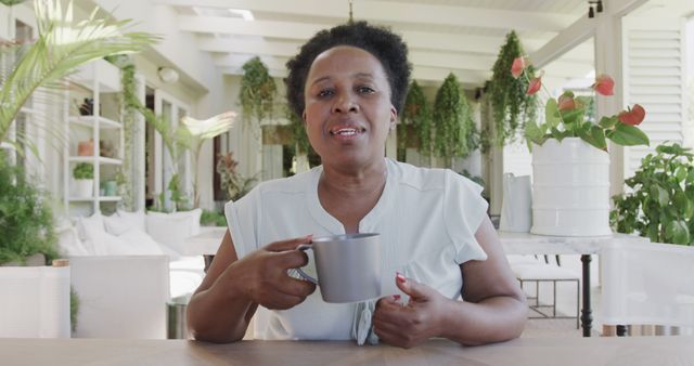 Mature Woman Relaxing With Coffee in Bright Outdoor Space - Download Free Stock Images Pikwizard.com