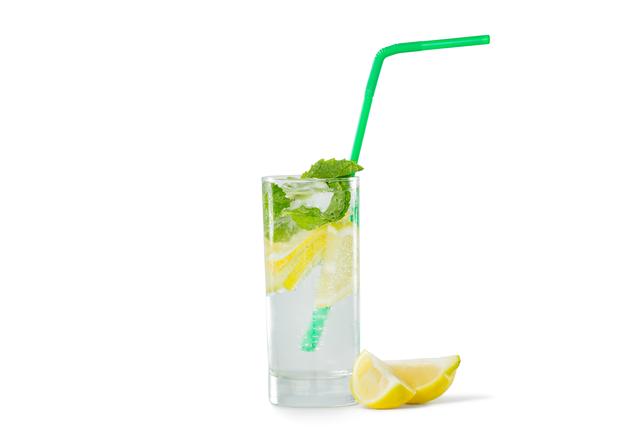Glass of mojito cocktail with lime on white background