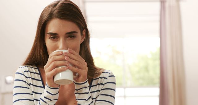 Young woman savoring a warm beverage indoors - Download Free Stock Images Pikwizard.com