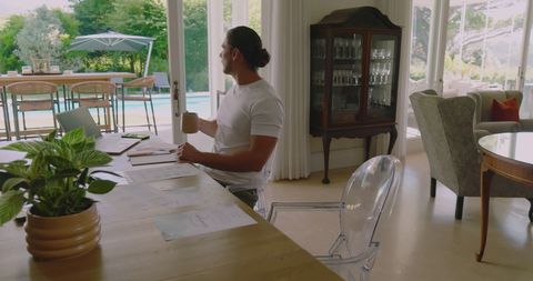 Man working remotely from home with scenic pool view