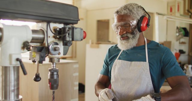 African american male carpenter drilling wood with a laser drill in a carpentry shop. carpentry, craftsmanship and handwork concept