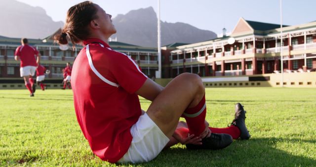 Rugby Player Injured Sitting On Field Holding Leg After Fall - Download Free Stock Images Pikwizard.com