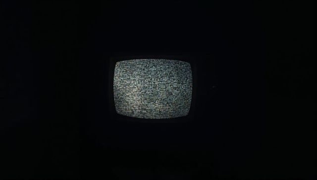 Retro crt television showing colorful static in dim light