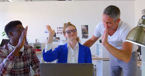 Business Colleagues Celebrating Success with High Fives in Modern Office
