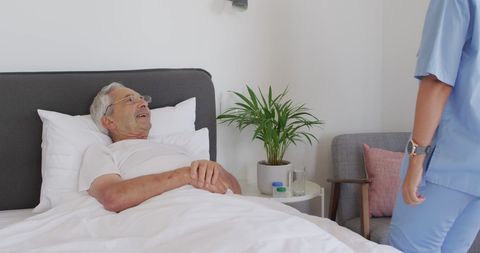 Nurse Caring for Senior Man in Hospital Room