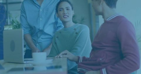 Woman Leading Team Meeting in Coworking Space with Laptop and Coffee