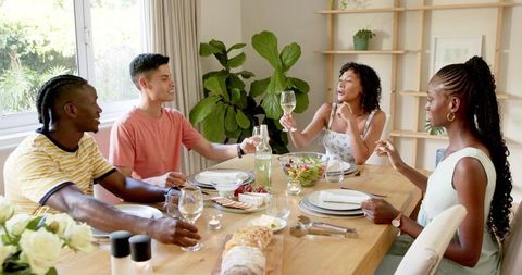 Friends Laughing and Enjoying Dinner at Home