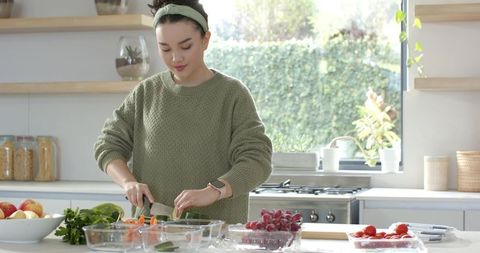 Young Woman Preparing Fresh Vegetables in Sunlit Modern Kitchen
