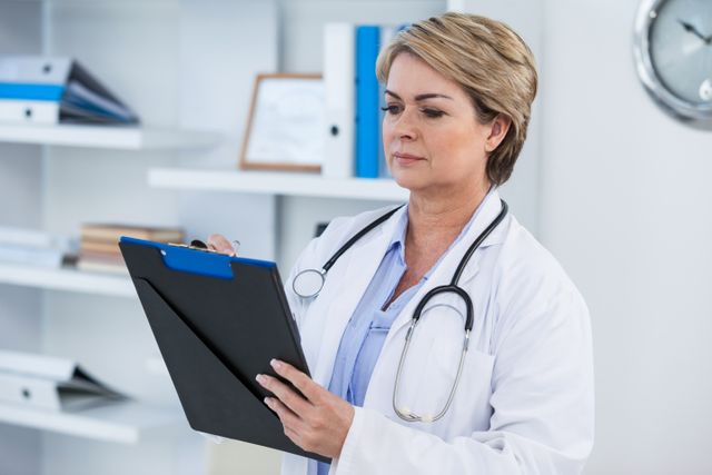 Female doctor writing on clipboard in medical office