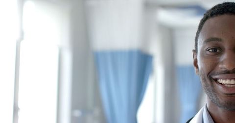 Cheerful doctor smiling in hospital corridor