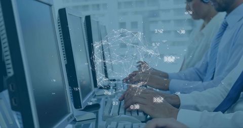 Diverse team typing at workstations with network data overlay representing analytics and collaborati