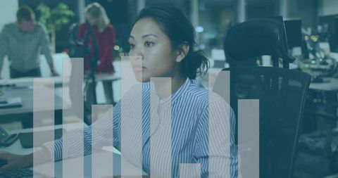 Asian woman working late in modern office analyzing data with translucent bar chart overlay