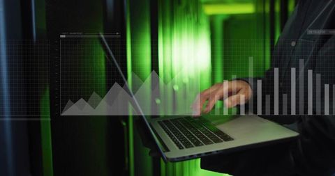 Korean IT engineer monitoring servers with laptop and data dashboards in green datacenter