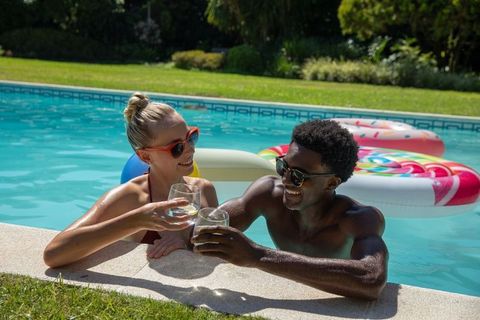 Couple Toasting Beverages by Sunny Poolside