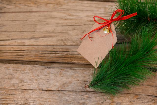 Christmas fir and tag on wooden plank during christmas time