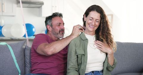 Couple Celebrating Birthday with Necklace Gift at Home