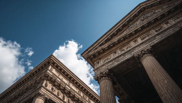 Classical facade rising against blue sky with corinthian columns and ornate entablature