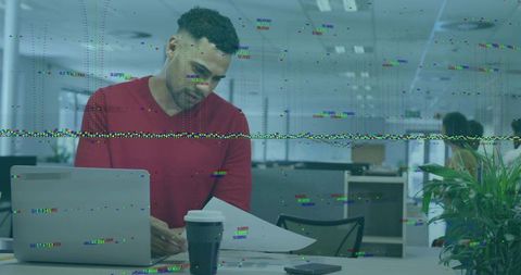 Focused professional reviewing documents in modern workspace