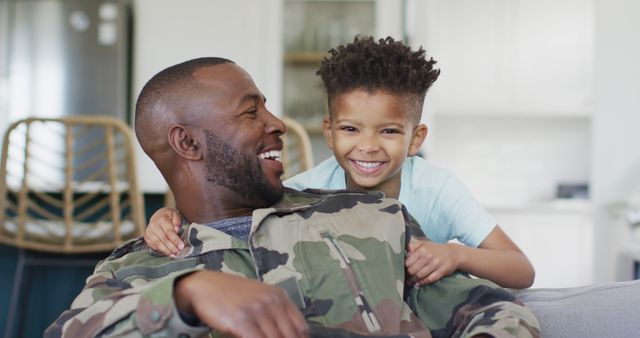 Portrait of happy african american father and his son embracing. Spending quality time at home.
