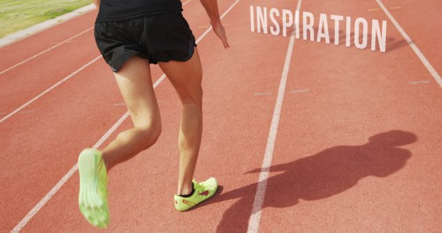 A young athlete is sprinting on a track field, with copy space. Their powerful stride and the word INSPIRATION emphasize the motivation and energy in sports training.