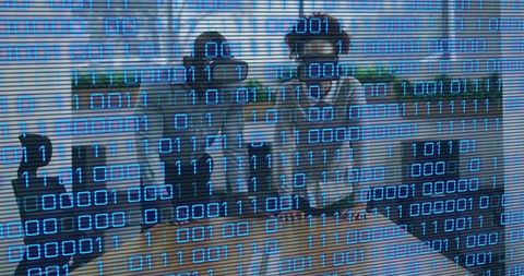 Developers testing virtual reality headsets with binary overlay, teamwork in modern office