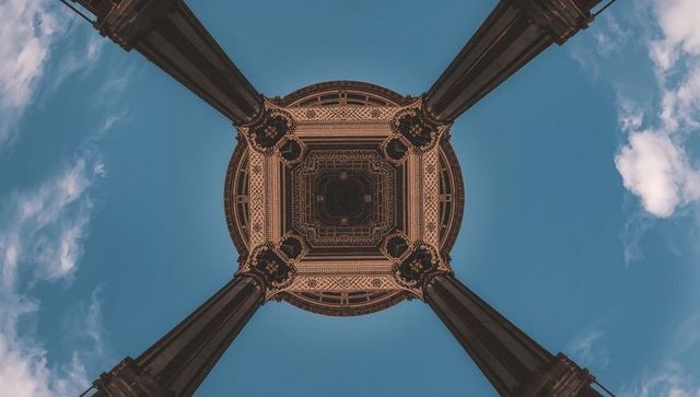 Looking up at ornate pavilion dome with four cast-iron columns, intricate geometric ceiling, clear b