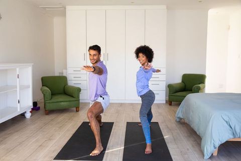 Friends Practicing Yoga in Bright Home Exercise Room