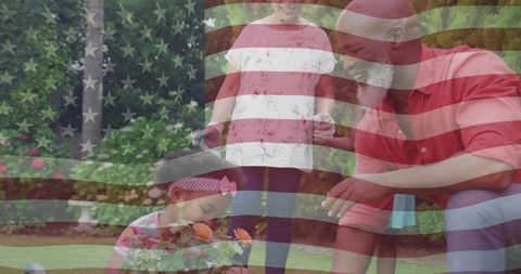 Grandfather gardening with granddaughters on sunny day