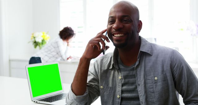 Smiling Man Talking on Mobile Phone in Modern Home Office - Download Free Stock Images Pikwizard.com