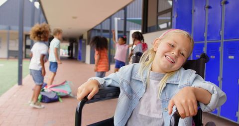 Joyful Girl in Wheelchair at School Corridor with Friends in Background