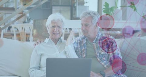 Senior Couple Exploring Digital Network on a Laptop at Home