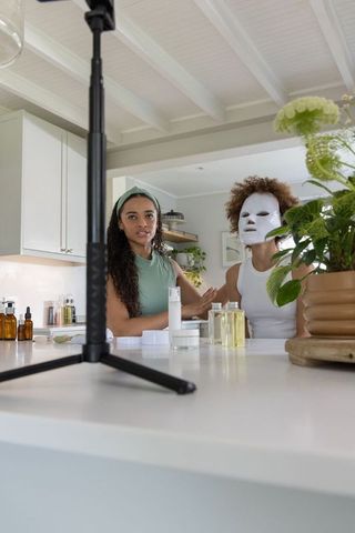 African american creators filming skincare tutorial at bright modern kitchen island