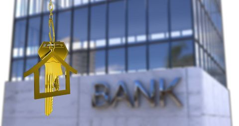 Golden house key with bank building background